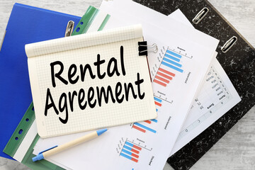 rental agreement work desk blue folder blue financial charts. text on a notebook