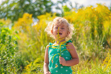 A child is allergic to ragweed blooming in the park. Selective focus.