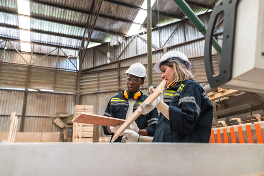 Wood worker man and woman checking wood planks wood assembly line manufacturing factory