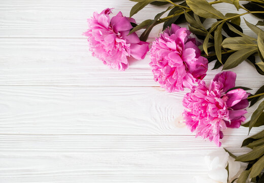 Top view with peonies on a wood table.Peony summer flowers bouquet. Lifestyle photo with flowers and a copy space.