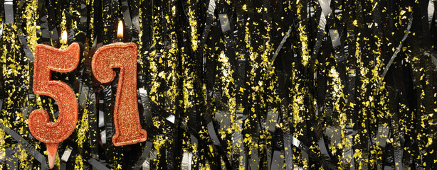 Burning red birthday candles on glitter tinsel background, number 57. Banner.