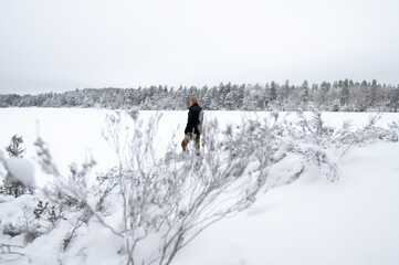 Man standing by snowy forest lake