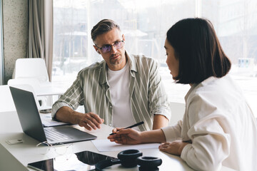 Male and female executive managers with modern laptop computer cooperate on business marketing...