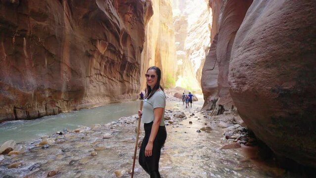 Woman hiking The Narrows in Zion National Park, Utah
