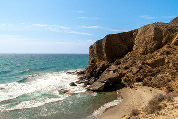 Cliffs next to Los Amarillos cove in the Mediterranean Sea. Small beach next to Genoveses beach at the end of summer. Nijar, Spain.