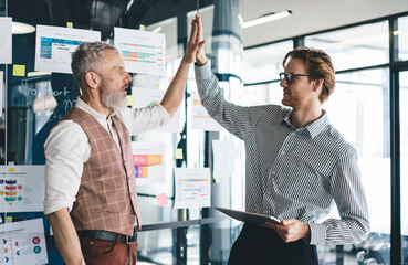 Senior businessman giving high five to male coworker