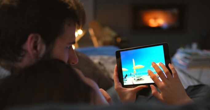 Tablet, screen and couple looking at pictures together for social media in living room at home. Rest, photography and people swipe images in gallery on digital technology relax on sofa in apartment.
