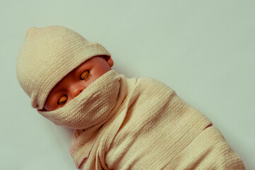 The doll the baby is wound with fabric. The body of the child is shrouded in a shroud. The concept...