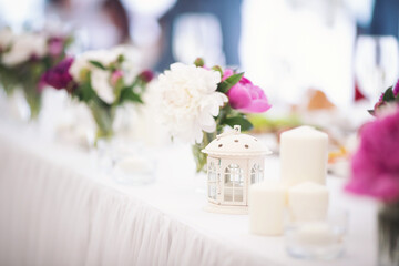Beautiful flowers on table in wedding day. Table decor with flowers table numbers and candles. Boquet of flowers  on arranged table. 