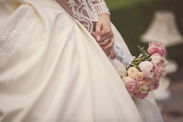 Elegant wedding bouquet in bride's hands. beautiful tender wedding bouquet of pink roses flowers in hands of the bride. 