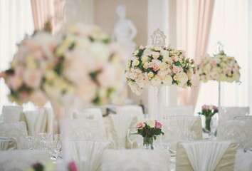 Beautiful flowers on table in wedding day. Table decor with flowers table numbers and candles. Boquet of flowers  on arranged table. 