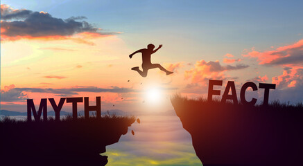 Silhouette man jumping from MYTH to FACT wording on cliffs with cloud sky and sunrise. Fact and Myth Concept.