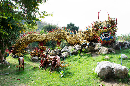 Art sculpture carving wooden chinese ancient dragon and wood antique snake naga gardening in garden park for thai people travel visit of Wat Tham Khao Prathun Temple at Banrai in Uthai Thani, Thailand