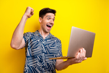 Photo of crazy man with bristle dressed blue clothes staring at laptop raising fist up win gambling...