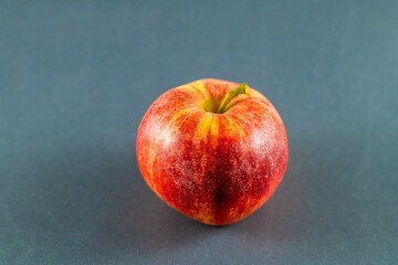 A close up view of a whole apple on a dark marble platter