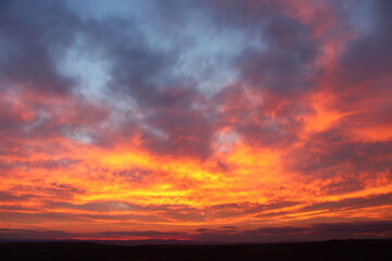 Fototapeta na wymiar A red sky behind clouds. amazing sunset