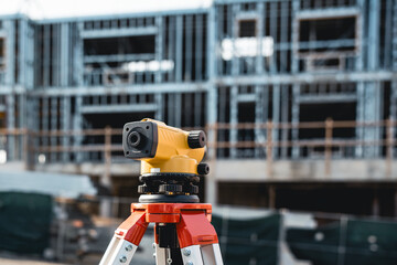 Construction auto level on a tripod at the building work site