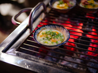 Vietnamese mini rice pan cakes garnished with shredded dried shrimps - banh khot. Vietnamese Street Food in Vietnam. banh khot on the warm ember stove kitchen. Food and travel concept.