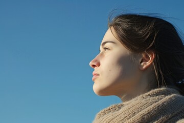 Serenity in profile, a woman bathed in the glow of tranquility, her gaze set upon the infinite blue.

