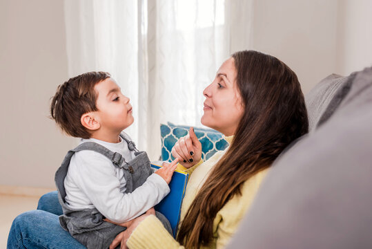 side view of Mother and toddler Son Sharing a funny Conversation on a Comfortable Living Room Couch