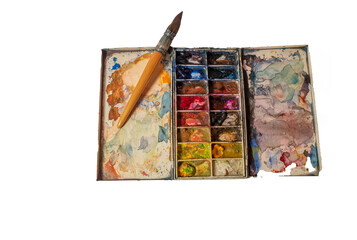 Watercolor palette and brush with mixed color remains forming a colored tapestry