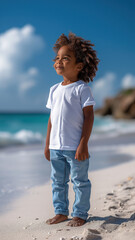 African boy in t-shirt and jeans on background of sandy beach of the sea.