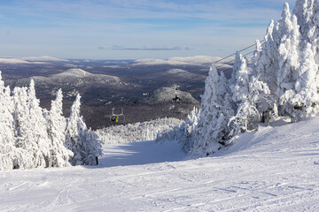 Fototapeta na wymiar Skiing at Mont Tremblant: A Winter Wonderland with Snowy Ski Slopes and Chairlifts Ascending Majestic Mountains - Experience the Thrill of Canadian Ski Resorts. Laurentians, Quebec, Canada