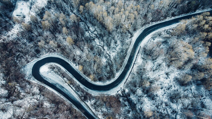 Aerial view of winding mountain road in winter.