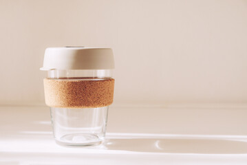 Reusable eco friendly glass cup on white background. Copy space for text. Sustainable lifestyle, zero waste and plastic free concept.