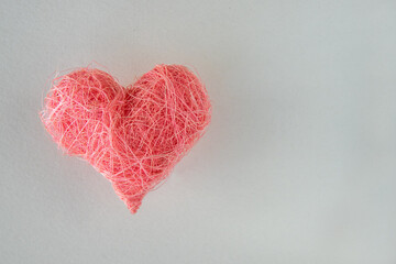 Pink fabric heart shape on the white background.