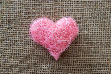 Pink fabric heart shape on the natural background.