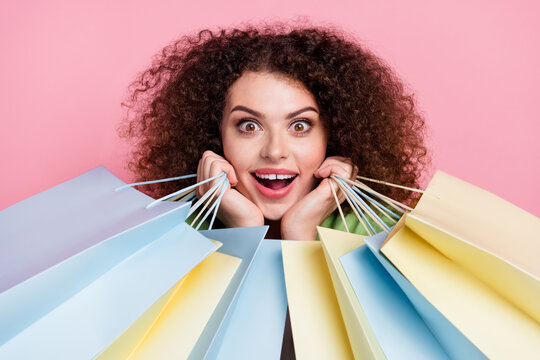 Photo portrait of attractive young woman admire charming hold shopping bags dressed stylish green clothes isolated on pink color background