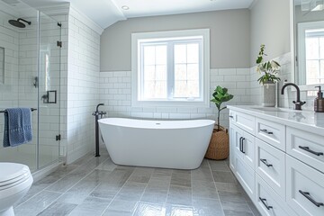 Fototapeta na wymiar Interior of modern minimalist Scandi style bathroom. White tiles, white classic cabinet with built-in sink, freestanding bath, glazed shower, indoor plant, large windows.