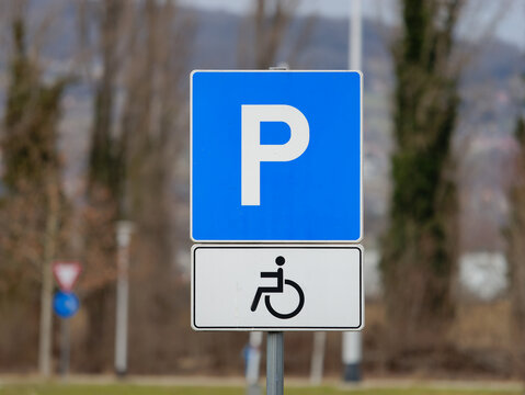 Close-up photo of a handicapped parking sign attached to a metal pole	