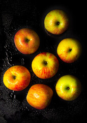 apples with splashes of water, apples on black glass.