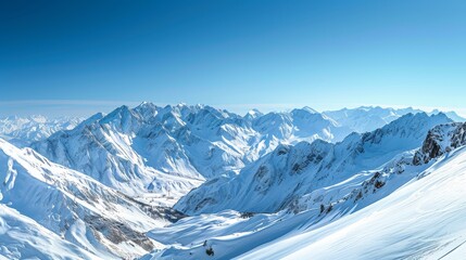Fototapeta na wymiar Wide panoramic view of a snow-covered mountain range with clear skies and deep valleys.