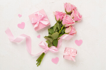 Pink roses with hearts and gift box on concrete background, top view. Valentines day concept