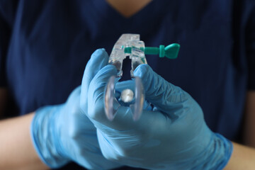 Professional holding a dilator for papanicolau exam in the hands point to the camera