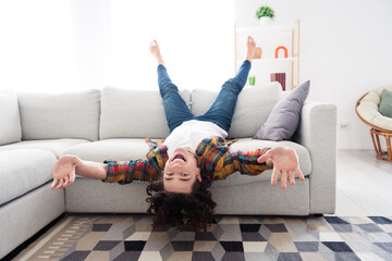 Photo of carefree good mood guy dressed checkered shirt lying sofa upside down having fun indoors...