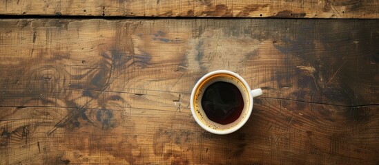 Morning time sees the placement of warm coffee atop a wooden surface.