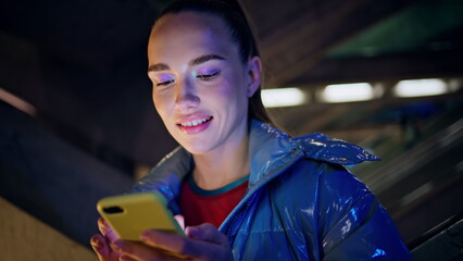 Portrait woman chatting social networks at night city. Girl face looking screen