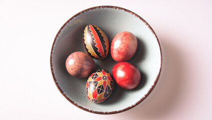 Easter eggs in a bowl on a light background with copy space