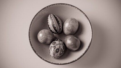 Easter eggs in a bowl on a light background with copy space