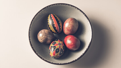 Easter eggs in a bowl on a light background with copy space