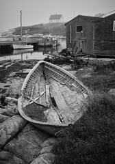 A broken down rowboat or skiff in black and white on the shorews of Peggys Cove Nova Scotia - 732022710