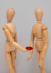 wooden mannequin holding a red heart