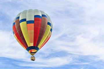 Naklejka premium Colorful hot air balloon flying over blue sky with white clouds 