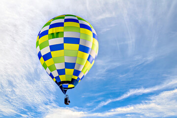 Fototapeta premium Colorful hot air balloon flying over blue sky with white clouds 