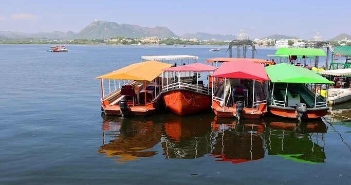 Colorful tour boats at the shoreline for tourist rides in the lake Pichola, Udaipur, India.