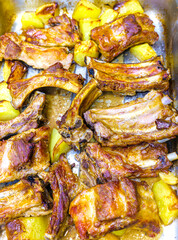 Baked pork ribs with potatoes in an oven tray. - 732027198